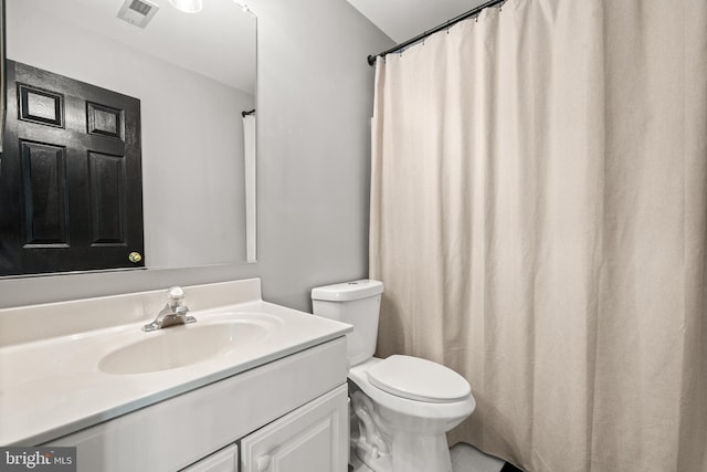 bathroom featuring visible vents, toilet, and vanity