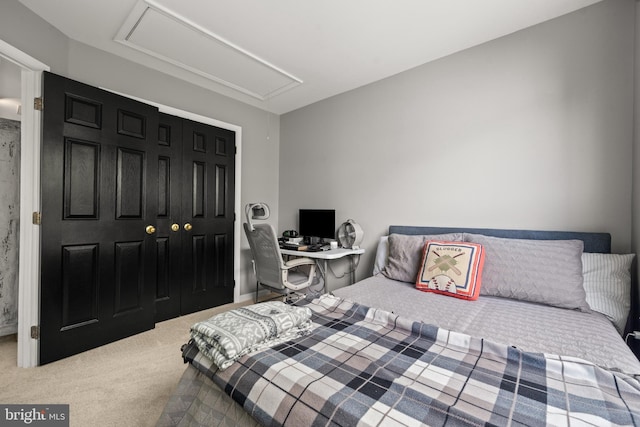 bedroom featuring attic access and carpet