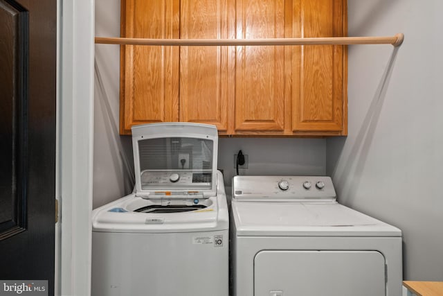 washroom with washing machine and dryer and cabinet space