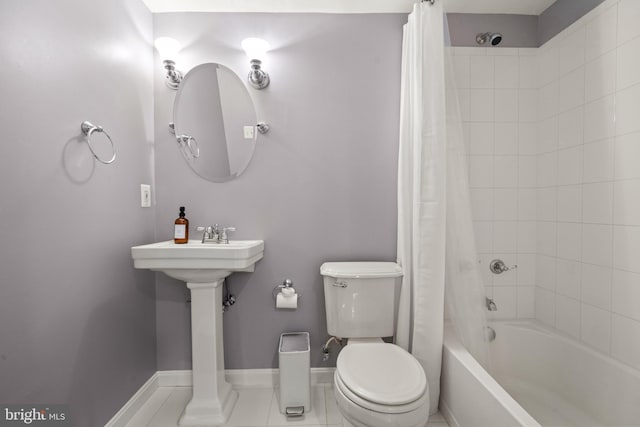 bathroom with toilet, baseboards, and shower / bath combo with shower curtain