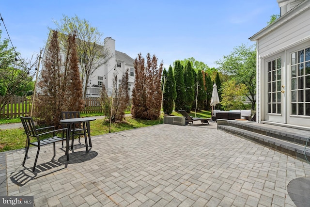 view of patio featuring fence, an outdoor living space, and french doors