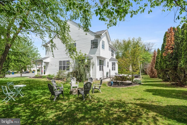 rear view of house featuring an outdoor fire pit, a patio area, and a yard