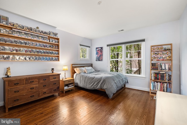 bedroom featuring dark wood-style flooring, visible vents, and baseboards