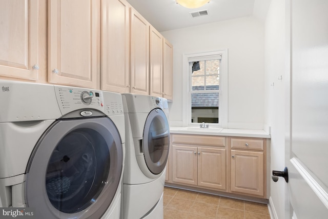 clothes washing area featuring visible vents, light tile patterned floors, washer and dryer, a sink, and cabinet space
