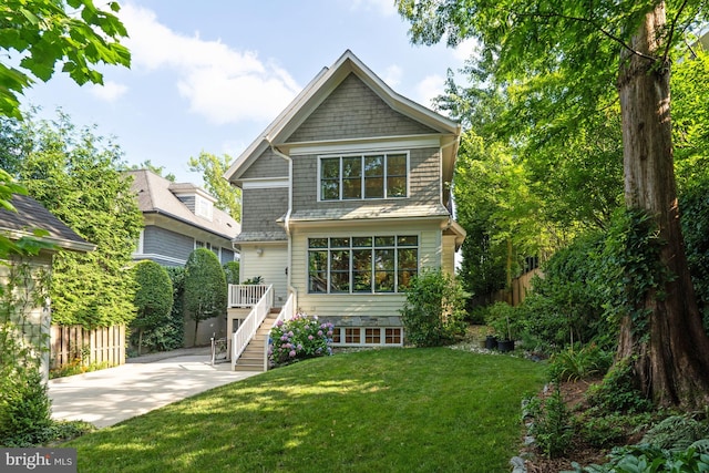 view of front of house with a patio, stairway, fence, and a front lawn