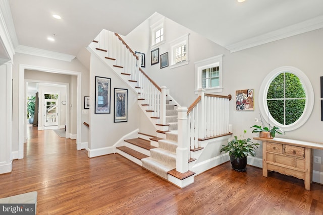staircase with recessed lighting, baseboards, ornamental molding, and wood finished floors