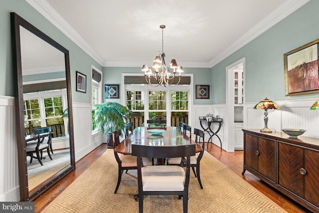 dining room with wainscoting, a notable chandelier, and wood finished floors