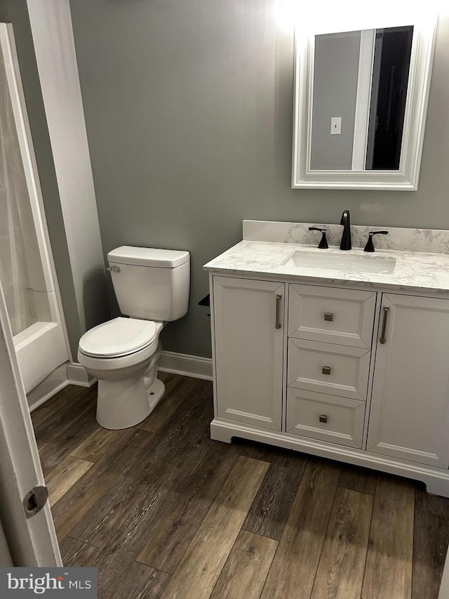 bathroom with vanity, baseboards, toilet, and wood finished floors
