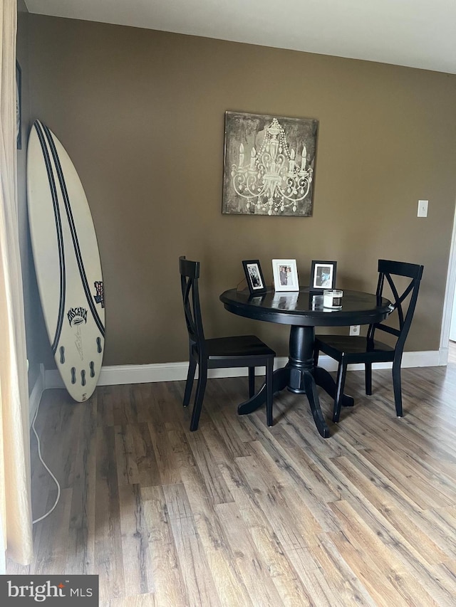 dining space with wood finished floors and baseboards
