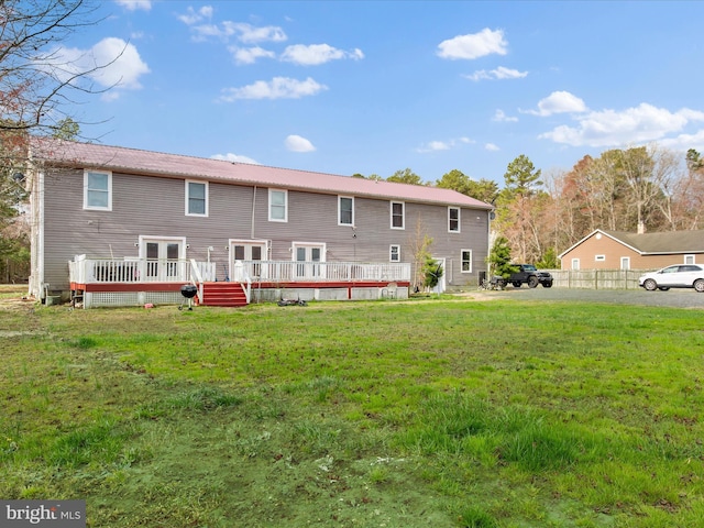 rear view of house with a yard and a wooden deck