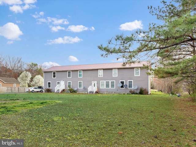rear view of property featuring a lawn