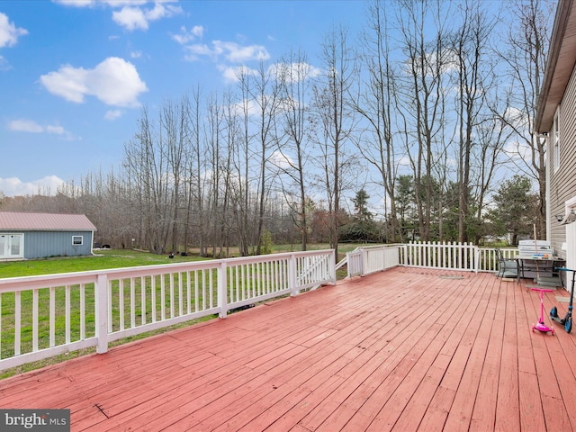 wooden deck featuring a lawn
