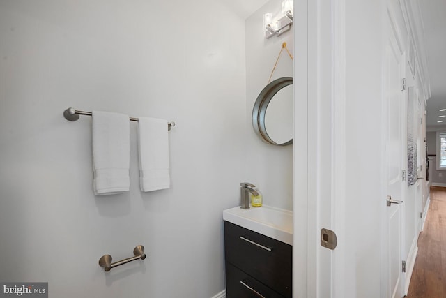 bathroom with wood finished floors, vanity, and baseboards
