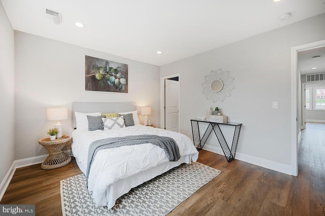 bedroom with wood finished floors, baseboards, and visible vents