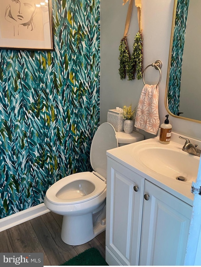 bathroom with toilet, wood finished floors, and vanity