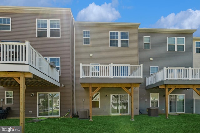back of house with central AC, a deck, and a lawn