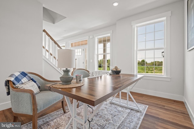 office space featuring baseboards, a healthy amount of sunlight, and wood finished floors