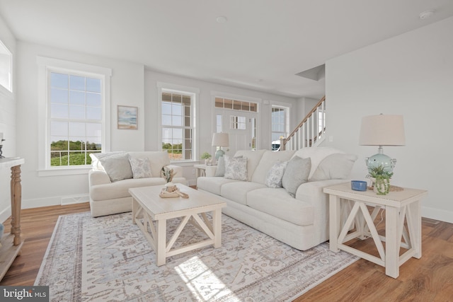 living area featuring wood finished floors, baseboards, and stairs