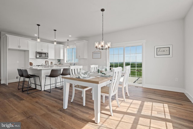 dining area featuring a wealth of natural light, a chandelier, wood finished floors, and recessed lighting