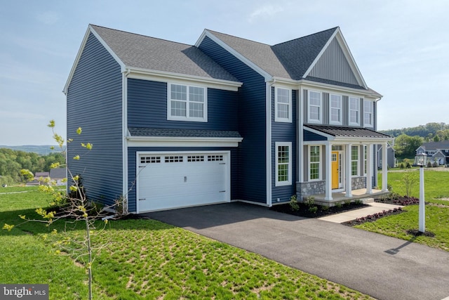 traditional-style home with driveway, an attached garage, a shingled roof, a porch, and a front lawn