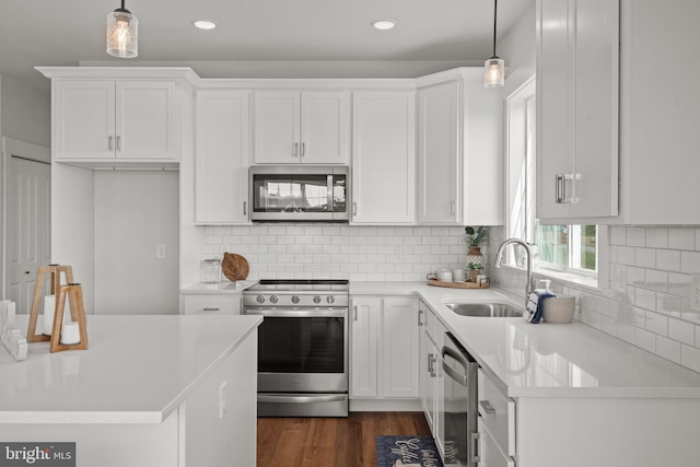 kitchen featuring a sink, stainless steel appliances, white cabinetry, and light countertops