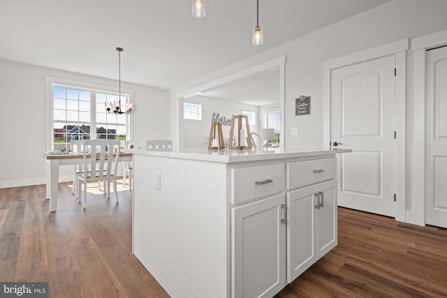 kitchen featuring decorative light fixtures, dark wood-style flooring, an inviting chandelier, white cabinetry, and light countertops