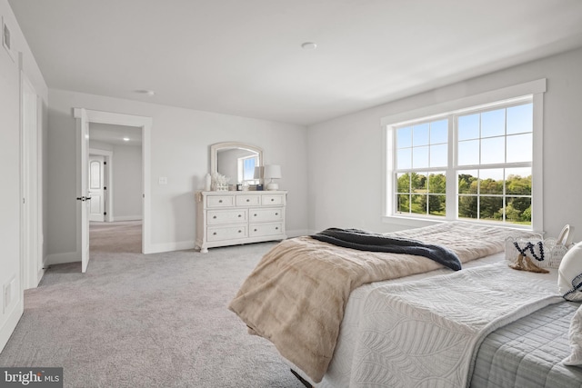 bedroom with light colored carpet, visible vents, and baseboards
