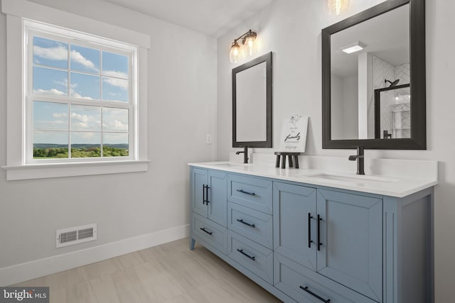 full bath with walk in shower, visible vents, baseboards, and a sink
