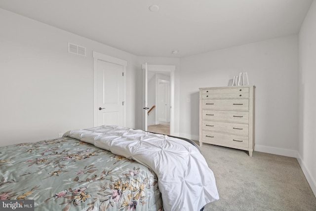 bedroom with baseboards, visible vents, and light colored carpet