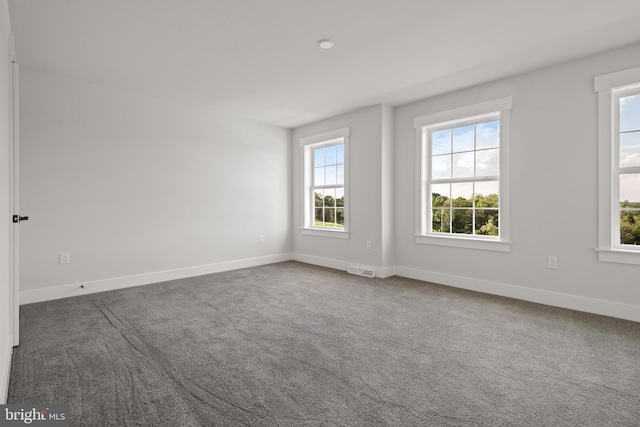 carpeted empty room with visible vents and baseboards
