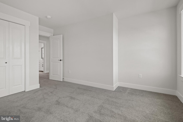 unfurnished bedroom featuring carpet, a closet, and baseboards