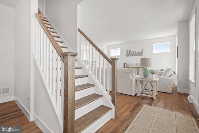 stairway featuring visible vents, wood finished floors, and baseboards