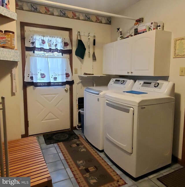 laundry room with washing machine and dryer, cabinet space, and tile patterned floors