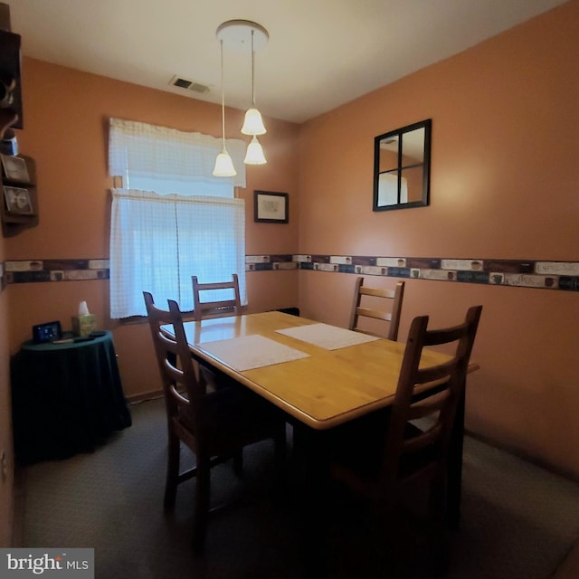 dining area with visible vents and dark carpet