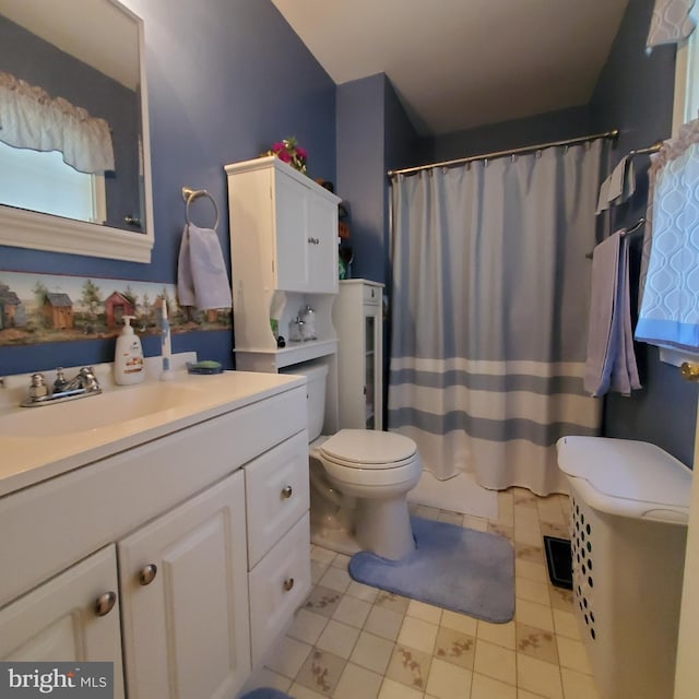 bathroom with tile patterned floors, vanity, toilet, and curtained shower