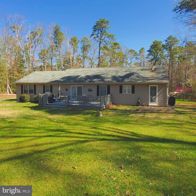 rear view of house featuring a deck and a yard