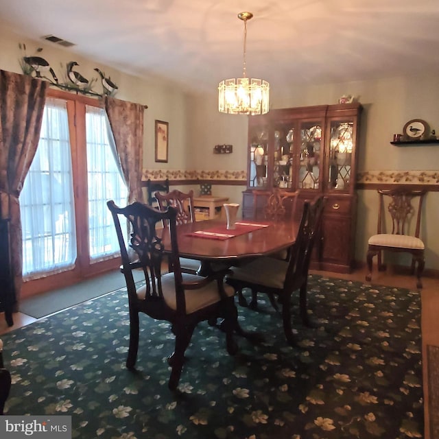 dining space featuring visible vents and a notable chandelier