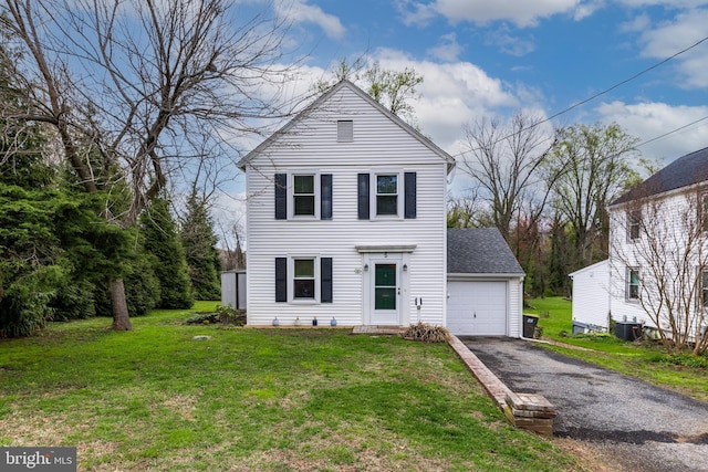 view of front of home featuring driveway, a front lawn, cooling unit, and a garage