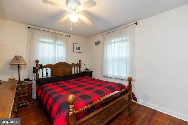 bedroom with a ceiling fan, multiple windows, wood finished floors, and visible vents