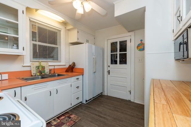 kitchen featuring white cabinets, a sink, dark wood finished floors, freestanding refrigerator, and a ceiling fan