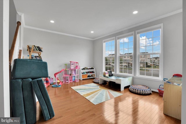rec room featuring crown molding, recessed lighting, and wood finished floors