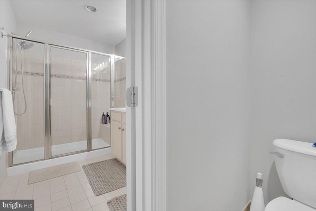 bathroom featuring a stall shower, tile patterned floors, and toilet