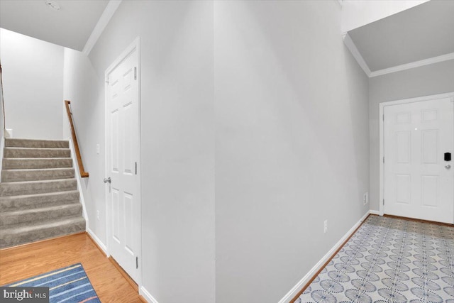 foyer entrance featuring stairway, crown molding, and baseboards