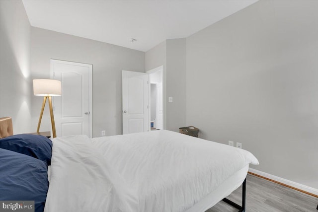 bedroom with wood finished floors and baseboards