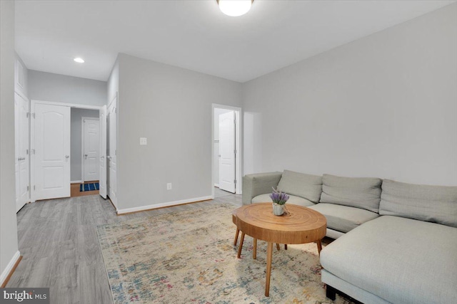living area with baseboards, recessed lighting, and wood finished floors