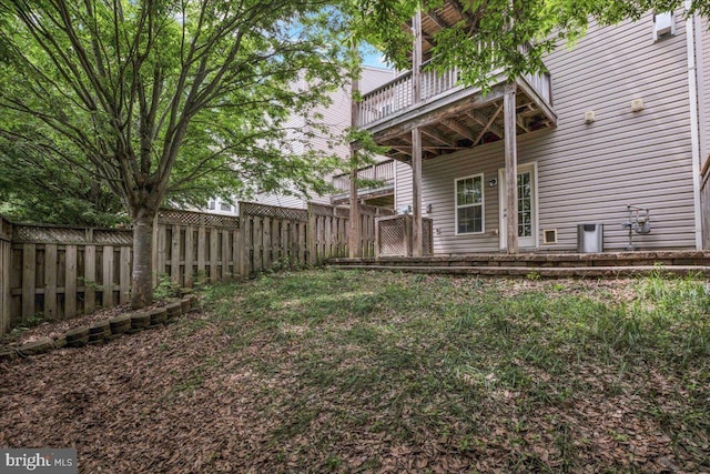 view of yard with a fenced backyard and a balcony
