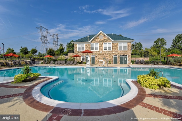community pool with fence and a patio