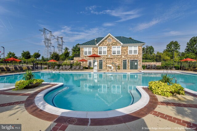 community pool with fence and a patio