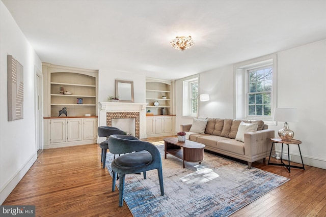 2314 Valley Rd, Huntingdon Valley, PA 19006 - living area with light wood-style floors, baseboards, built in features, and a brick fireplace