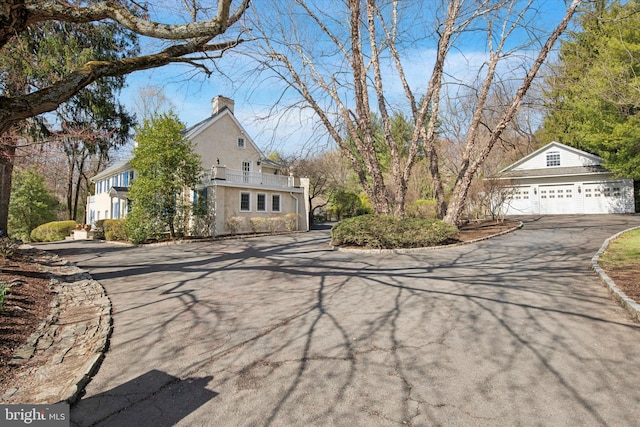 2314 Valley Rd, Huntingdon Valley, PA 19006 - view of front of property with a balcony, stucco siding, a chimney, a detached garage, and aphalt driveway